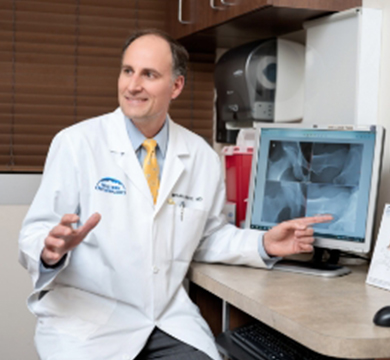 Dr. White in his office talking to a patient about X-Rays.